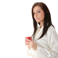 Portrait of beautiful woman drinking water against white background