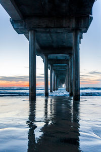 Bridge over sea against sky during sunset