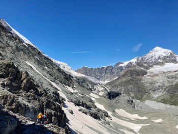 Scenic view of snowcapped mountains against clear blue sky