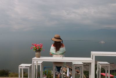 Woman looking at sea against sky