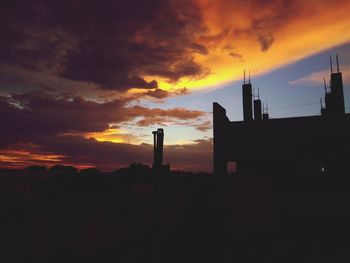 Silhouette buildings against sky during sunset