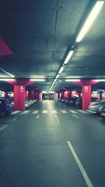 Empty road in illuminated city at night