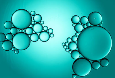 Close-up of bubbles over water against blue background