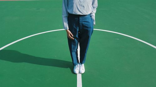 Low section of man standing soccer field