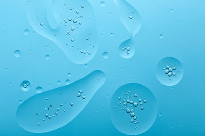 Close-up of water drops on blue glass