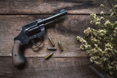 High angle view of handgun and bullets by plant on table