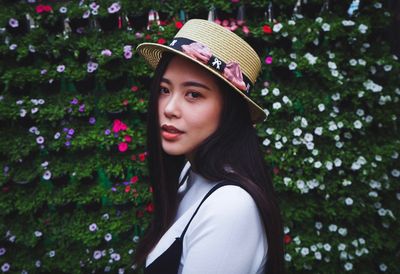 Beautiful young woman looking at flower tree