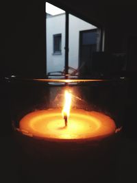 Close-up of lit candle in dark room