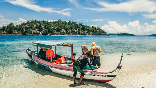 People at beach against sky