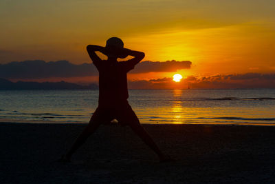 Silhouette man at beach during sunset