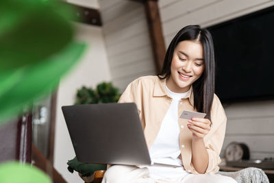 Portrait of young woman using laptop at home