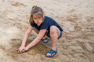 Portrait of girl playing on sandy beach