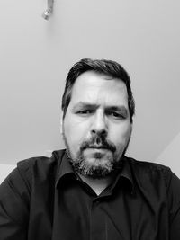 Portrait of mature man against wall at home