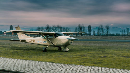 Airplane flying over airport runway against sky