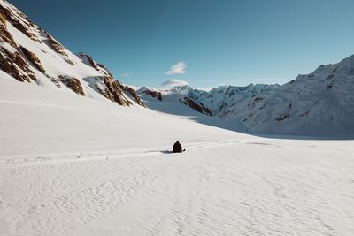 Rear view of person on snowcapped mountain against sky