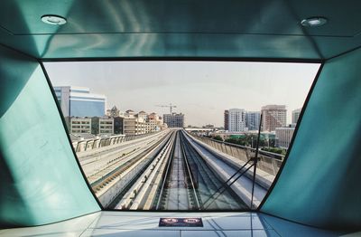 Train on railroad tracks in city against sky