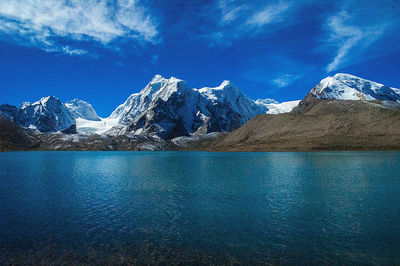 Scenic view of snowcapped mountains against blue sky