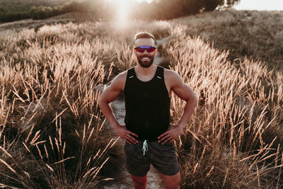 Young man wearing sunglasses standing on field