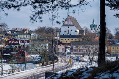 Bridge leading towards buildings in city during winter
