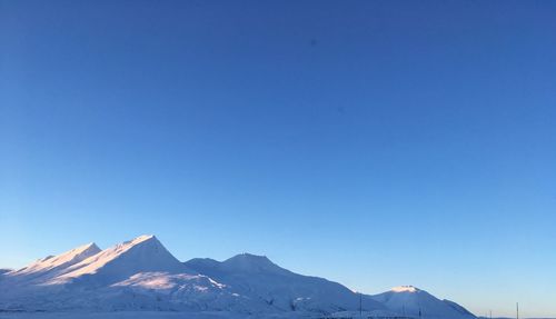 Scenic view of snowcapped mountains against clear blue sky