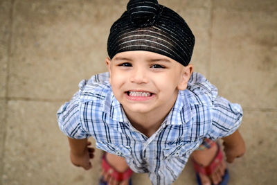 Portrait of cute boy smiling while standing on tiled floor