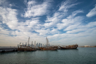 Sailboats in sea against sky