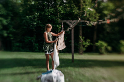 Young woman hanging up laundry on an outdoor clothesline 