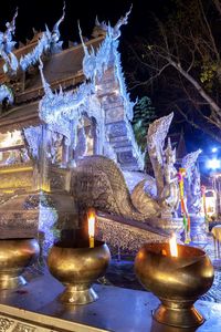 Illuminated statue against temple