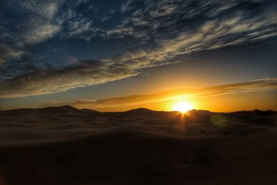 Scenic view of desert against sky during sunset