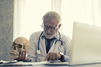Doctor with skull reading document