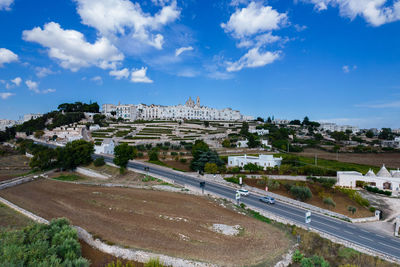 High angle view of road by buildings against sky