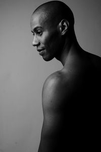 Portrait of young man looking away against white background