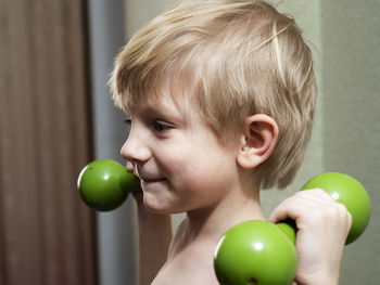 Close-up portrait of shirtless boy holding apple