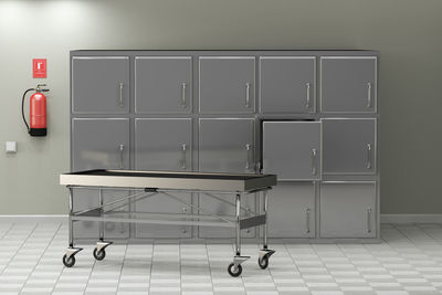 Stretcher on floor against metallic cabinets in hospital