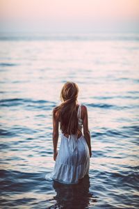 Rear view of woman standing in sea