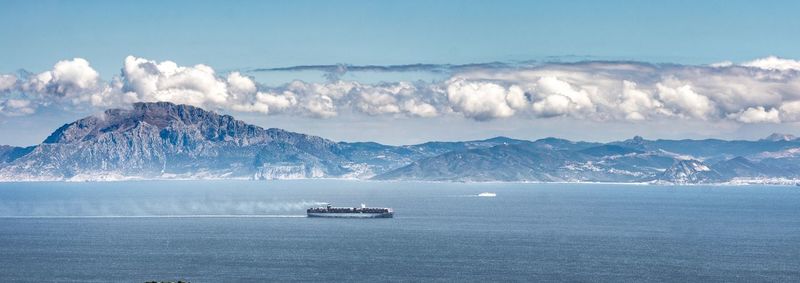 Scenic view of sea and mountains against sky