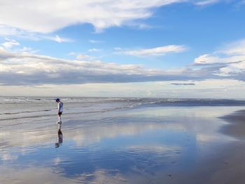 Man standing on beach against sky