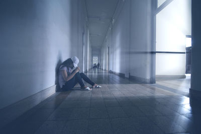 Woman sitting in corridor