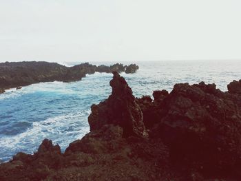 Scenic view of sea with rocks in background