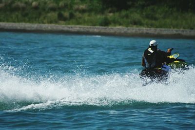 Rear view of man riding jet ski on lake