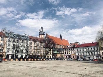 Buildings in city against cloudy sky