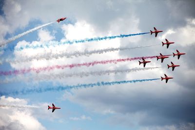 Low angle view of airshow against sky