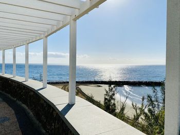 Swimming pool by sea against sky