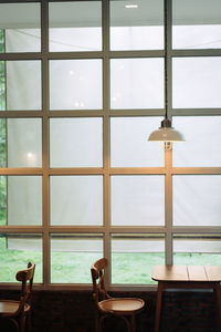 Empty chairs and tables in glass window