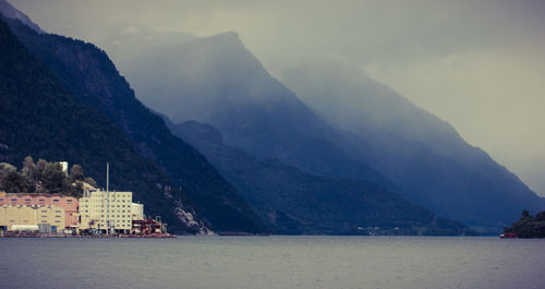 Scenic view of lake by mountains against sky