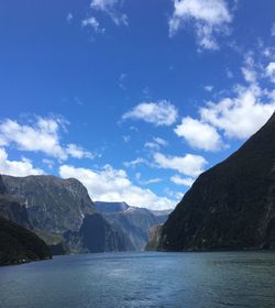 Scenic view of lake and mountains against blue sky