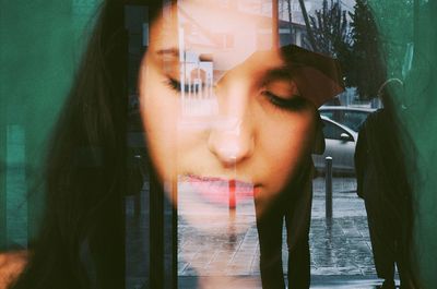 Close-up of sad woman seen through glass window