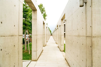 Empty footpath amidst buildings