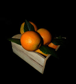 Close-up of orange fruit on table against black background