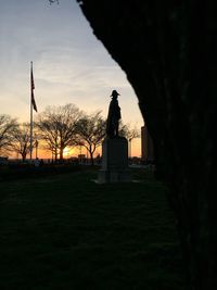 Silhouette of woman statue at sunset